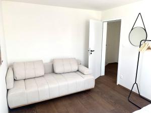 a white couch in a living room with a mirror at Prázdninový dům Mikulov in Mikulov