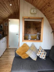 a couch in a room with a mirror and a clock at Portree Pod in Portree