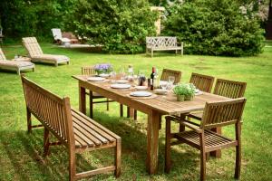 een houten tafel met vier stoelen en een tafel met wijnglazen bij Landhaus Dodo in Payerbach
