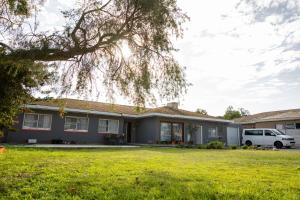 a house with a car parked in a yard at Lyronne Guest house, Shuttle and Tours in Cape Town