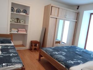 a bedroom with a bed and a table and a window at KATY&MLADEN in Baška