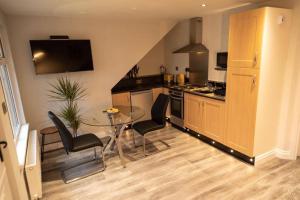 a kitchen with a table and chairs and a dining room at Adorable First Floor 1-bedroom Loft with decking in Omagh