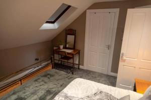 1 dormitorio con cama y escritorio con espejo en Adorable First Floor 1-bedroom Loft with decking, en Omagh