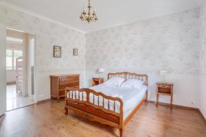 a bedroom with a bed and a chandelier at Villa Le Deck - Grande maison familliale proche plage in Arcachon