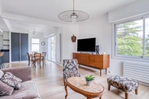 a living room with a couch and a tv at Villa Le Deck in Arcachon