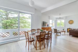 a dining room and living room with a table and chairs at Villa Le Deck in Arcachon