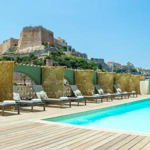 uma piscina com espreguiçadeiras ao lado de um castelo em Solemare em Bonifacio