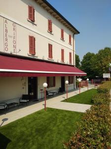 budynek z czerwoną markizą obok trawnika w obiekcie Albergo Grifone 1891 w mieście Peschiera del Garda