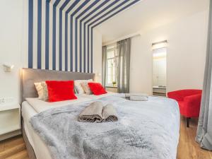 um quarto com uma cama grande e almofadas vermelhas em Glow Apartments, Apartament Długa 69 em Gdansk