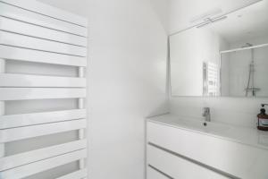 a white bathroom with a sink and a mirror at Villa Le Deck - Grande maison familliale proche plage in Arcachon +16 photos