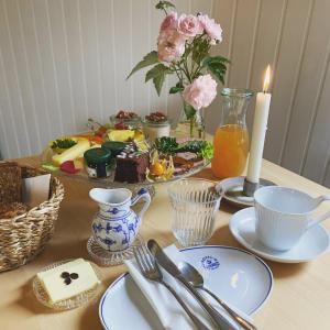 una mesa cubierta con platos de comida y una vela en Rønhave en Sønderborg