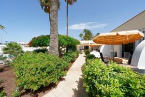 - une terrasse avec un parasol à côté d'une maison dans l'établissement Bungalows Granada Beach, à Playa del Ingles