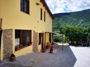 ein gelbes Haus mit einer Terrasse und einem Berg in der Unterkunft Agriturismo B&B Il Girasole in Roccadaspide