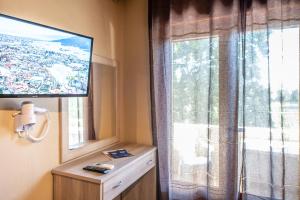 a room with a window with a television and a dresser at Yannis Hotel in Krinídhes