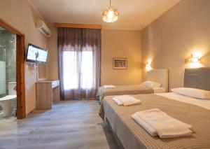 a hotel room with two beds and a flat screen tv at Yannis Hotel in Krinídhes