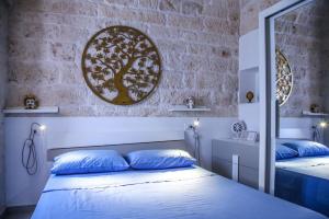 a bedroom with two beds with blue pillows and a brick wall at Casa del sole in Ceglie Messapica