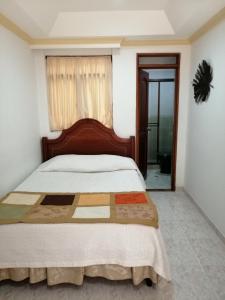 a bedroom with a bed with a wooden head board at Hotel Bolivar Plaza in Manizales