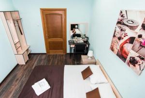 a bedroom with a bed and a desk with a person in a mirror at Гостиница Бизнес Турист in Barnaul