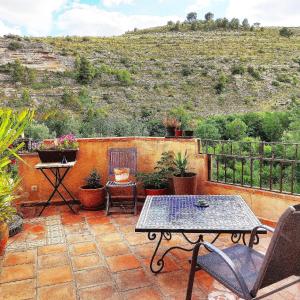 un patio con mesa, sillas y una colina en Al-Axara Home Spa, en Cubas