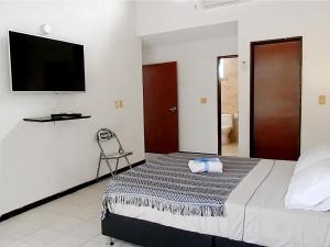 a bedroom with a bed and a flat screen tv at 5E Hotel Boutique in Girardot