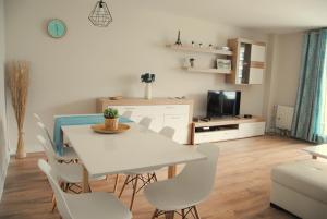 ein Wohnzimmer mit einem weißen Esstisch und Stühlen in der Unterkunft Apartamento Dulcinea in Alcalá de Henares