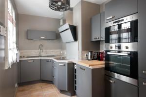 una cocina con fregadero y estufa horno superior en Maison Telline, en Saint-Martin-de-Ré