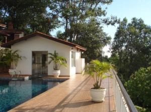 a villa with a swimming pool and a house at Casa na Montanha (Serra Negra) in Serra Negra
