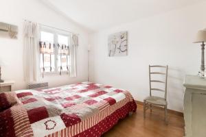 un dormitorio con una cama y una silla en Maison Telline, en Saint-Martin-de-Ré