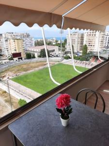 eine Vase mit einer Blume auf einem Tisch vor einem Fenster in der Unterkunft Disy Apartments in Vlorë