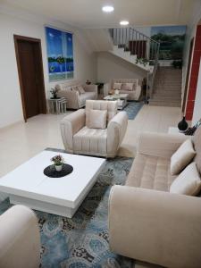 a living room with white couches and a table at شقة دورين 4 غرف نوم في منطقة هادئه - لغير المدخنين - تقع في الدور الأول - لايوجد مصعد - تبعد عن وسط بريده 8 دقائق in Buraydah