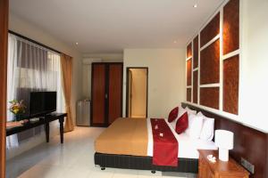 a hotel room with a bed and a television at Sanur Seaview Hotel in Sanur