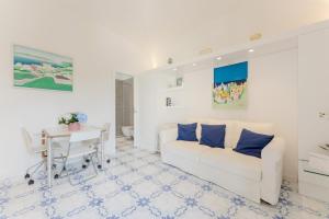 Azzurra, Capri في كابري: غرفة معيشة بيضاء مع أريكة بيضاء وطاولة +21 صورة