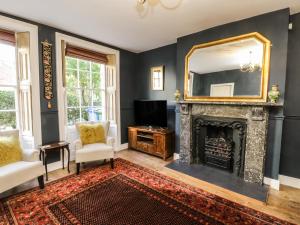 a living room with a fireplace and a mirror at Stewart House in Whitby