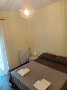 a bedroom with a bed with two towels on it at Casa Renzo in LʼAquila