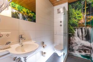 a bathroom with a shower, sink, and tub at Hotel Krehl in Laichingen