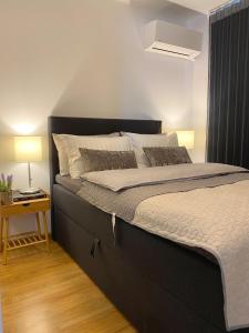 a large bed in a bedroom with a side table at Snow Sheep apART - апартамент с две спални in Ruse