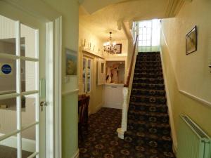 a hallway with a staircase leading up to a room at Southcliff Guest House in Tenby