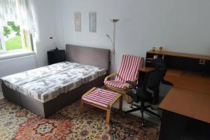 1 dormitorio con cama, escritorio y silla en Apartmán na Náměstí ve Štramberku, en Štramberk