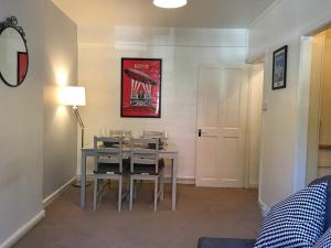 a dining room with a table with chairs and a lamp at Marble Apartments Effra Court in London