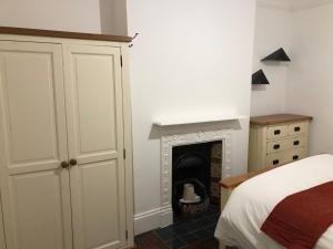 - une chambre avec un lit et une cheminée dans l'établissement Marble Apartments Tooting Broadway, à Londres