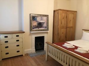 a bedroom with a bed and a fireplace at Marble Apartments Tooting Broadway in London