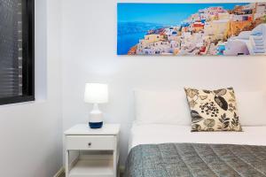 una camera da letto con un letto con un cuscino e una foto appesa al muro di Balmain Modern Apartments a Sydney