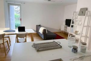 a white living room with a couch and a table at Appartamento a Santa Maria Maggiore in Valle Vigezzo in Santa Maria Maggiore