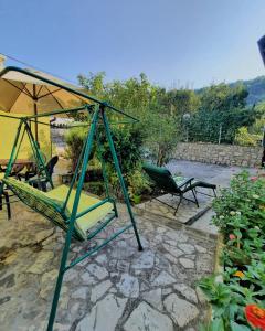 a patio with a swing and an umbrella at Holiday Home CASTLE in Bihać
