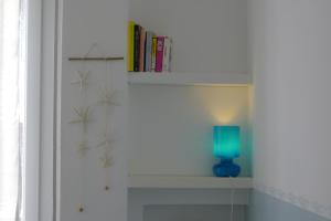 un estante con una lámpara azul y libros en él en Casa Stefania Igea Marina en Bellaria-Igea Marina