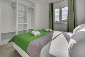 ein Schlafzimmer mit einem Bett mit zwei Handtüchern darauf in der Unterkunft Green Point Paklenica in Starigrad-Paklenica