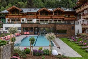 an exterior view of a hotel with a swimming pool at Hotel Stadt Wien in Zell am See