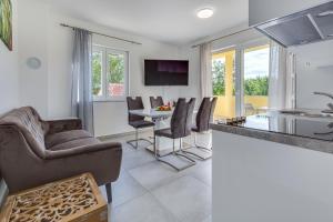 eine Küche und ein Wohnzimmer mit Tisch und Stühlen in der Unterkunft Green Point Paklenica in Starigrad-Paklenica