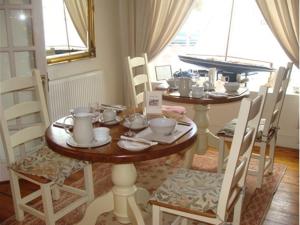 ein Esszimmer mit einem Tisch und Stühlen sowie einem Tisch und einem Stuhl in der Unterkunft The Old Brewhouse in Cirencester