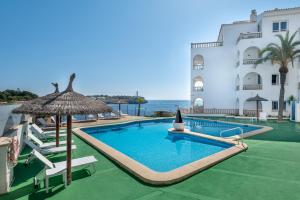 une piscine en face d'un bâtiment dans l'établissement Orange Colom - Seaside Apartments, à Portocolom